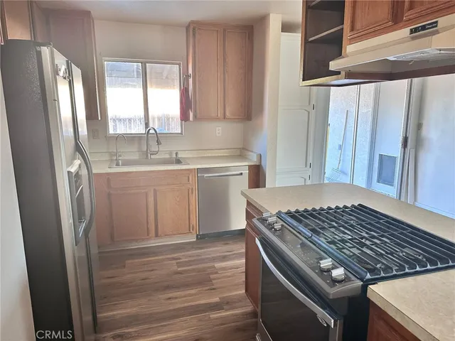 a kitchen with stainless steel appliances granite countertop a stove a sink and a refrigerator