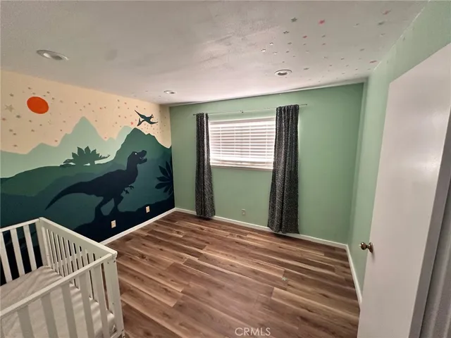 a bedroom with a bed and a painting on the wall