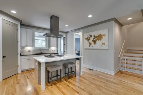a kitchen with stainless steel appliances granite countertop a stove refrigerator and wooden floor