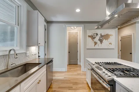 a kitchen with stainless steel appliances a stove a sink and a refrigerator