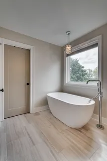 a bathroom with a white tub sitting next to a window