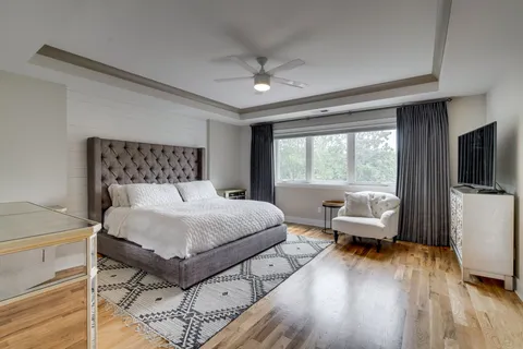 a bedroom with a bed and large windows