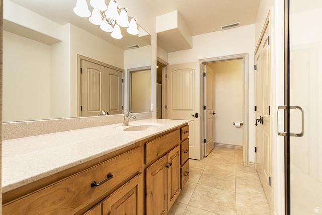 888 East Fiddlers Canyon Road Cedar City, UT 84721 - Photo 45 of 74 Full bathroom featuring vanity, light tile patterned floors, and a chandelier