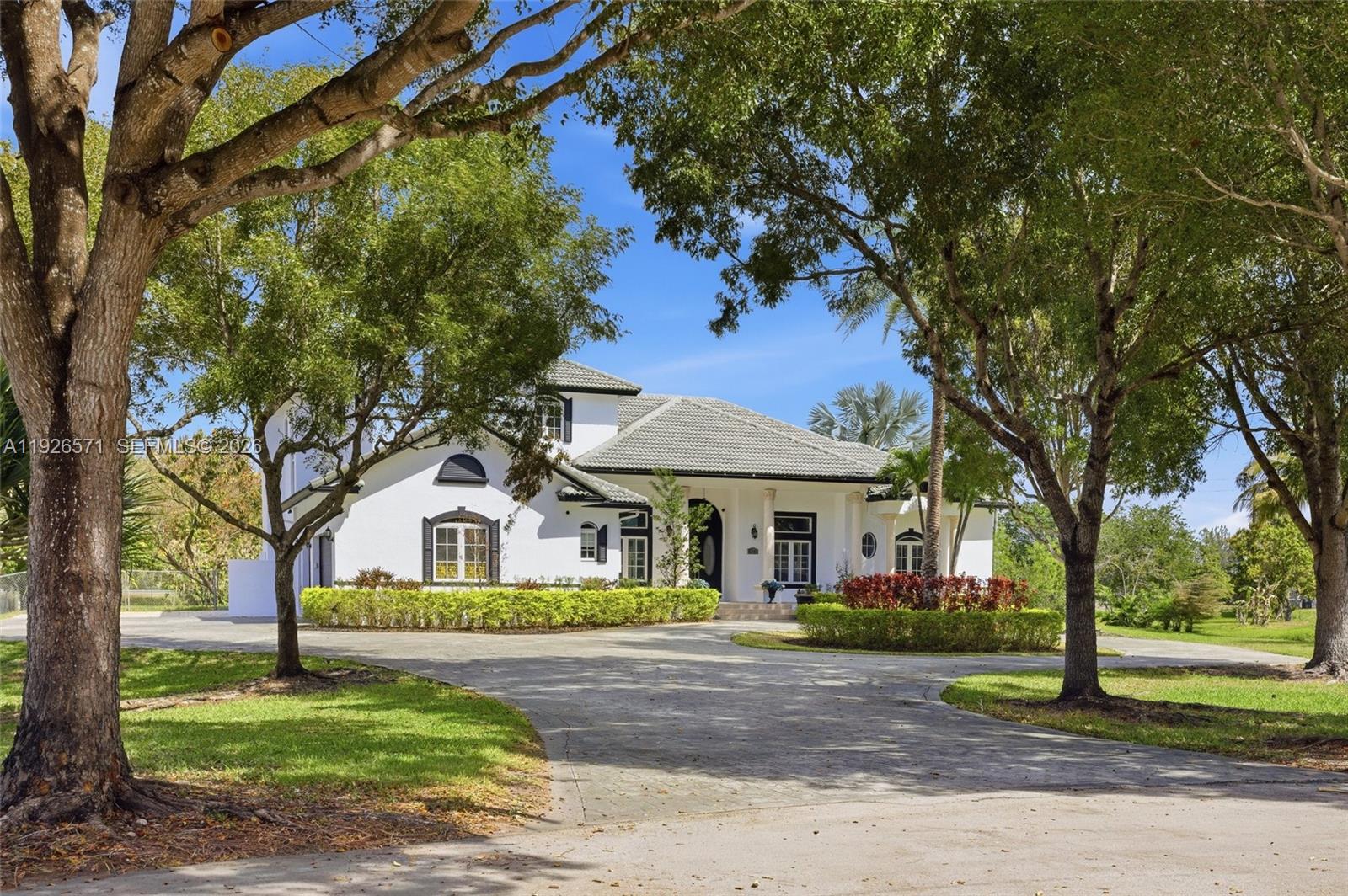 20401 Southwest 48th Place Southwest Ranches, FL 33332 - Photo 13 of 55 a front view of a house with garden