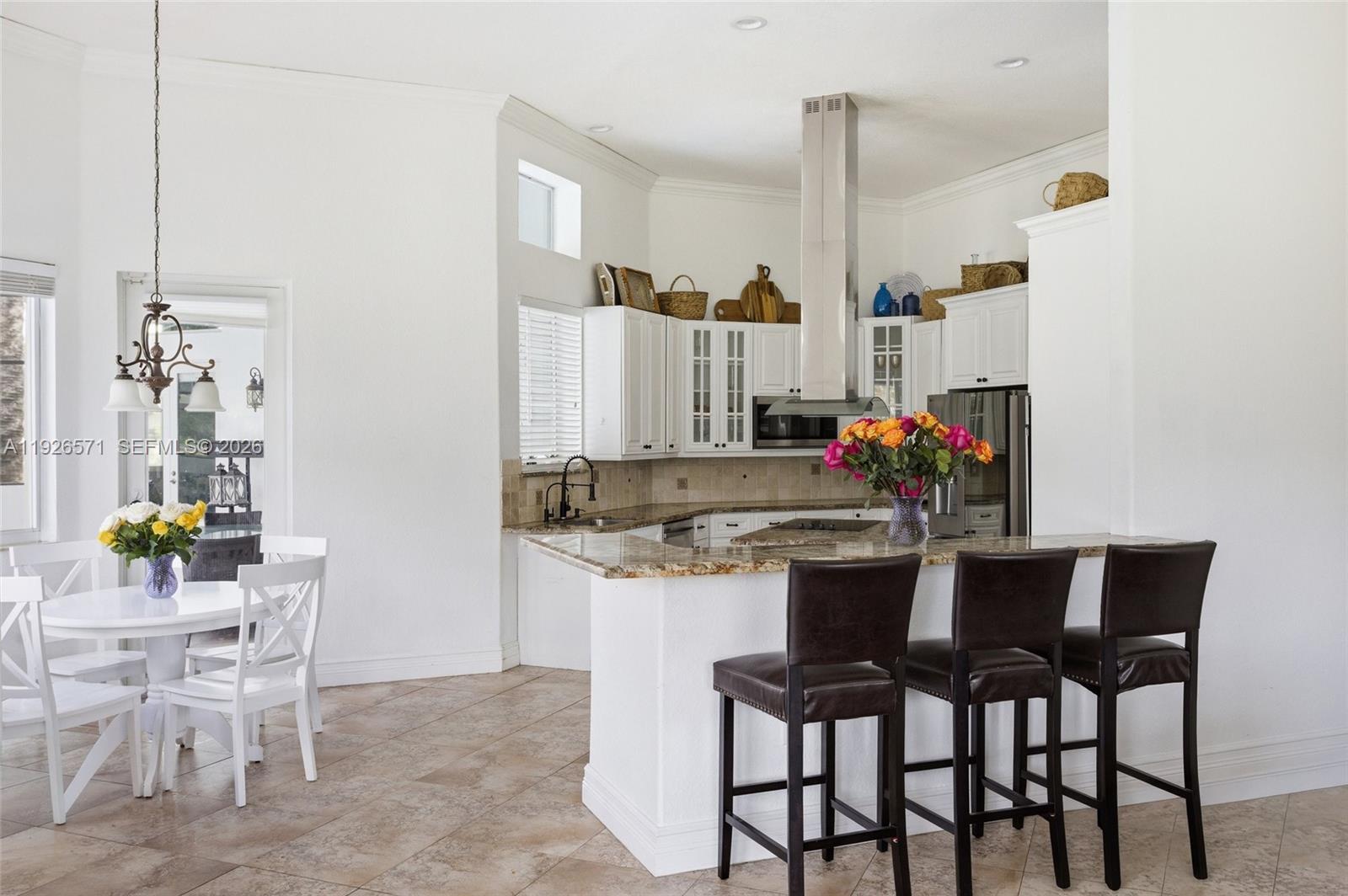 20401 Southwest 48th Place Southwest Ranches, FL 33332 - Photo 22 of 55 a kitchen with stainless steel appliances kitchen island granite countertop a table and chairs