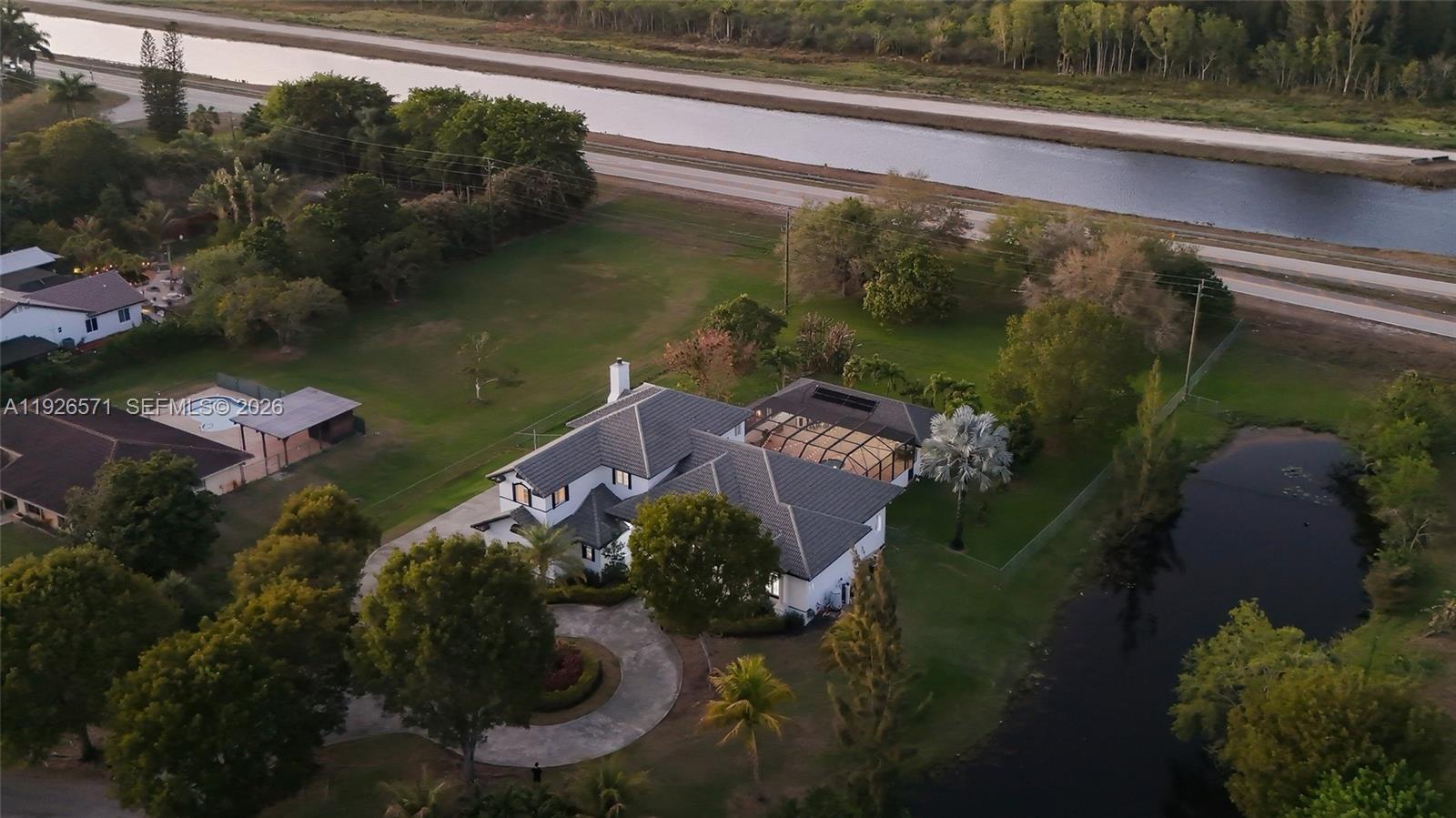 20401 Southwest 48th Place Southwest Ranches, FL 33332 - Photo 41 of 55 a view of a lake with a house in the background