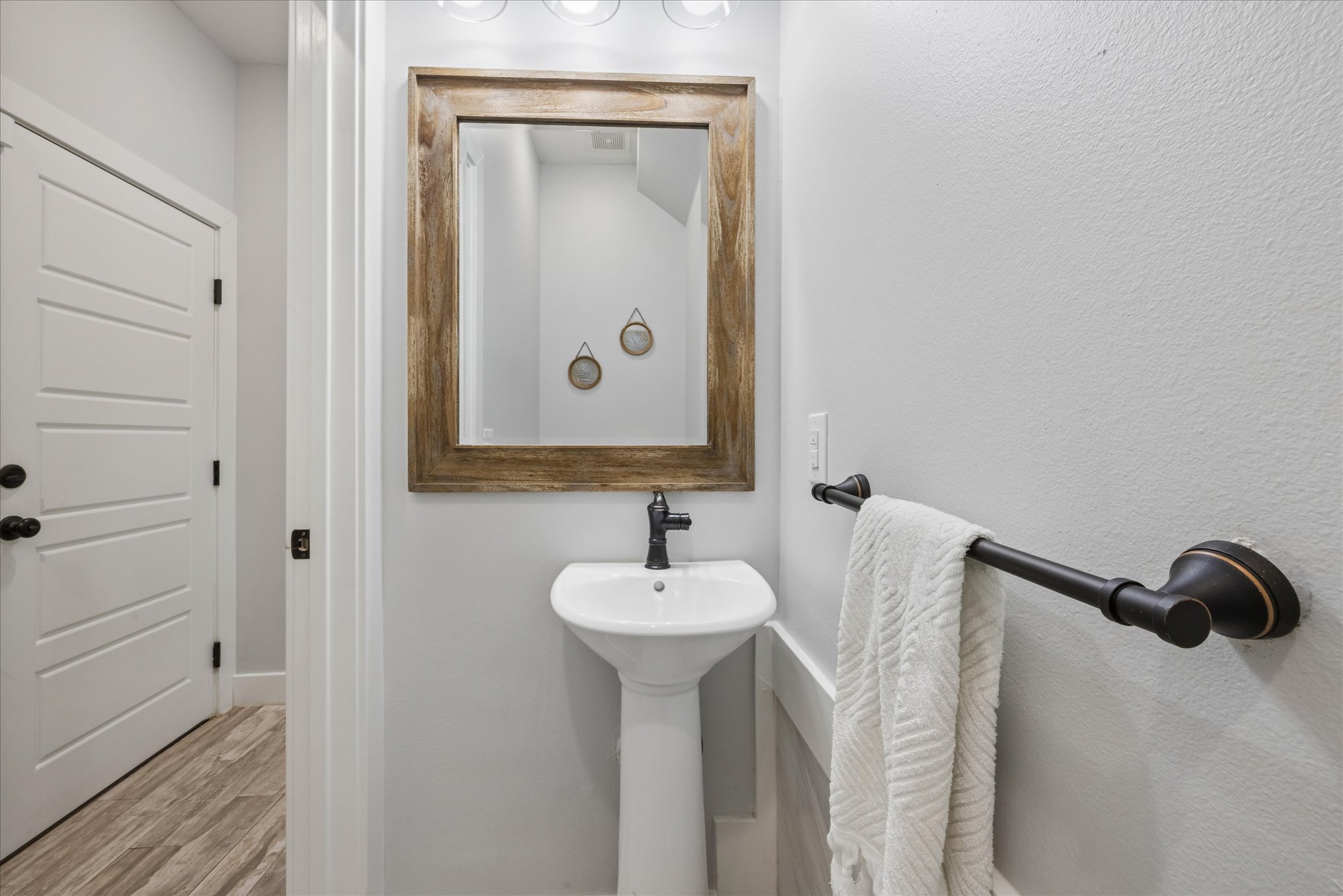 116 Mallard Road Bastrop, TX 78602 - Photo 19 of 31 A classic pedestal sink pairs beautifully with textured wood flooring in this powder room.