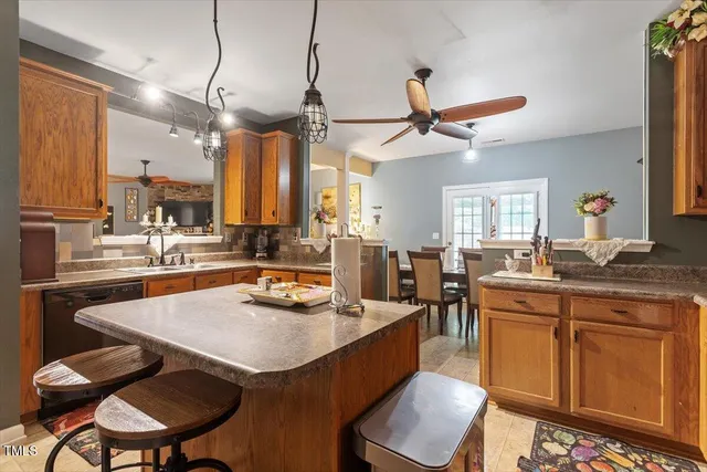 a kitchen with a dining table chairs sink and wooden floor