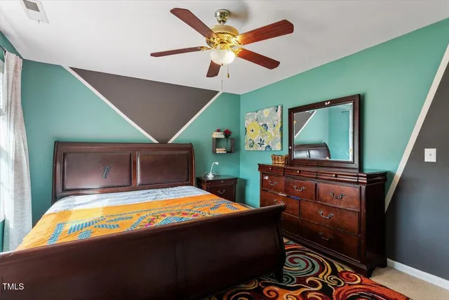 a bedroom with a bed and a dresser with a bookshelf