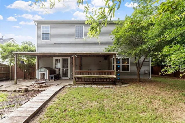 a view of a house with a yard and large tree