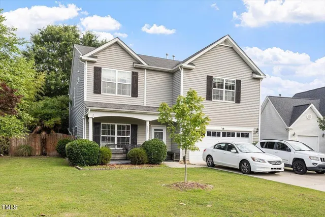 a car parked in front of a house with a yard