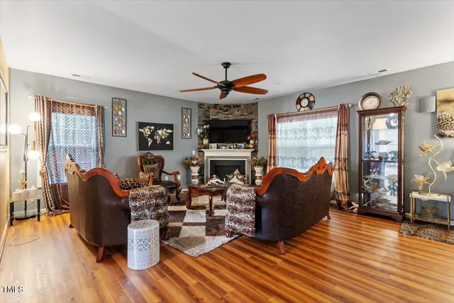 a living room with fireplace furniture and a wooden floor