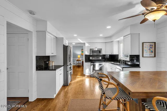 a large kitchen with a table chairs refrigerator and a stove top oven