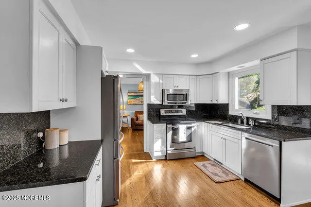a kitchen with stainless steel appliances granite countertop a sink stove and refrigerator