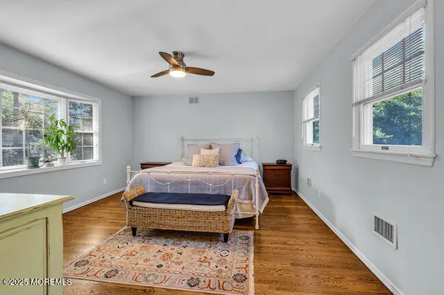 a bedroom with a bed wooden floor and window
