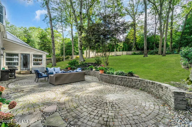 a view of a patio with table and chairs potted plants and large tree