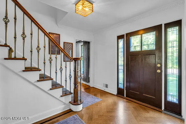 a view of entryway with wooden floor and stairs