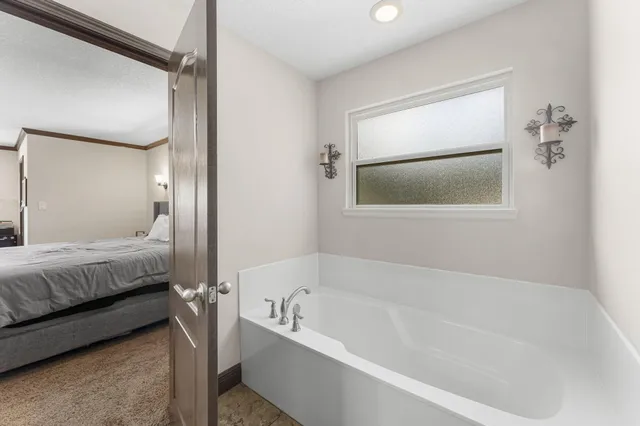 a kitchen with a refrigerator a sink and a view of living room
