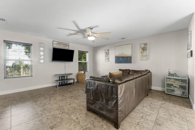 a living room with furniture a ceiling fan and a rug