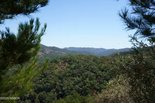 a view of a patio with table and chairs under an umbrella with a fire pit