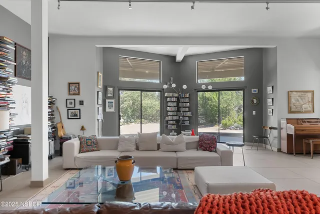 a living room with patio furniture and a large window