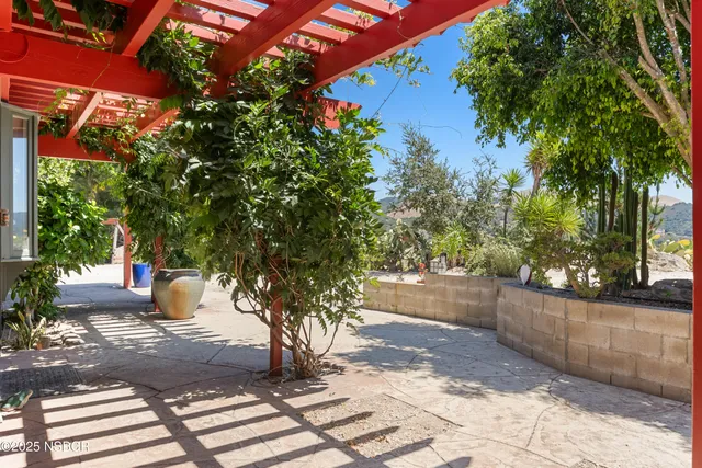 a view of a livingroom with wooden floor stairs and a way to ceiling window