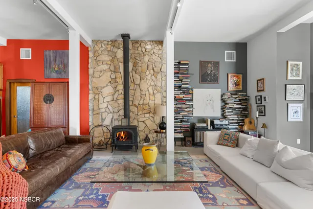 a living room with furniture a rug and white walls