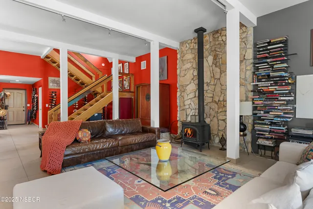 a kitchen with stainless steel appliances granite countertop a stove a refrigerator a dining table and chairs with wooden floor