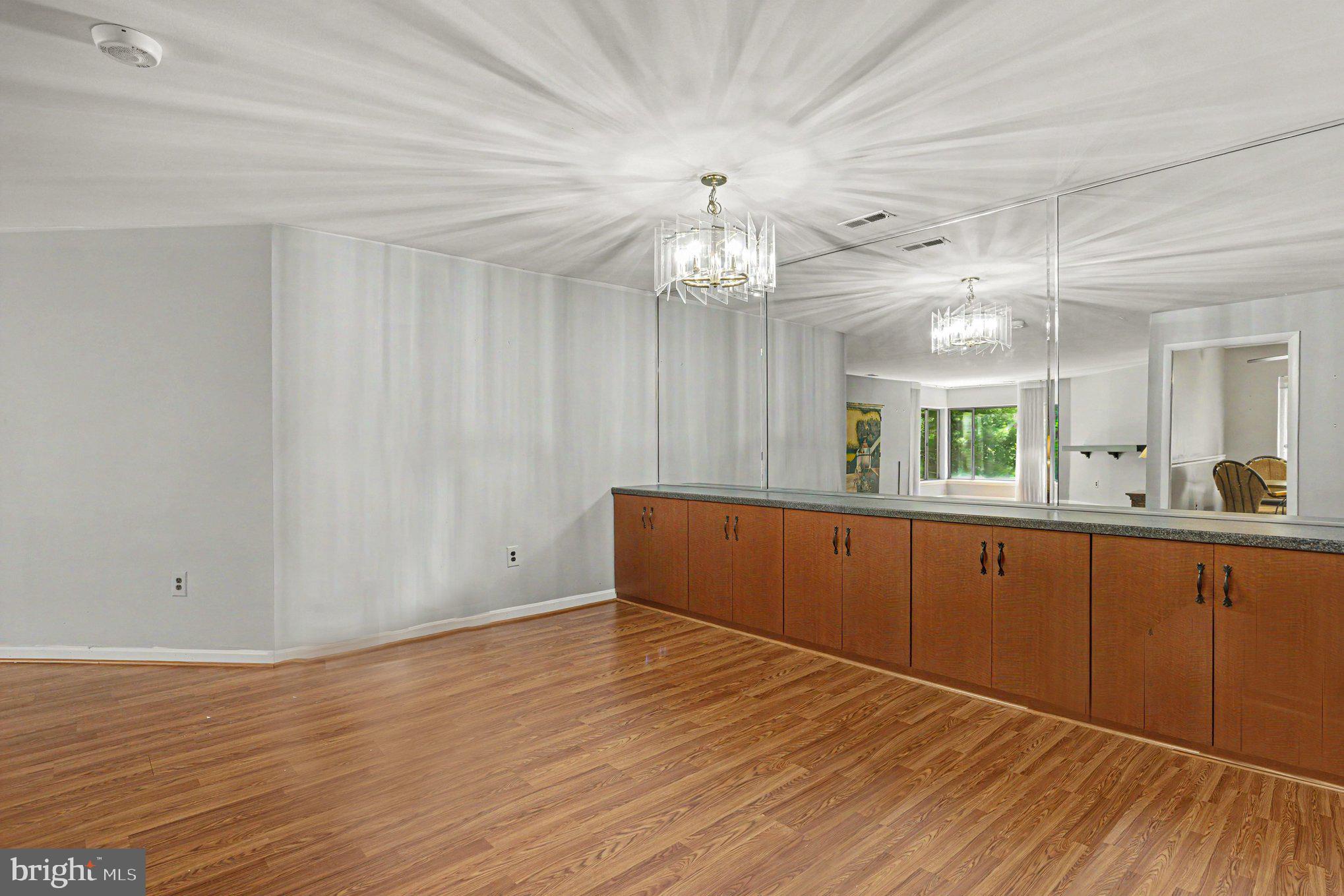 3021 Fallstaff Road, Unit 208B Baltimore, MD 21209 - Photo 7 of 25 a view of cabinets with wooden floor and chandelier