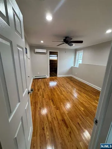 a view of empty room with wooden floor