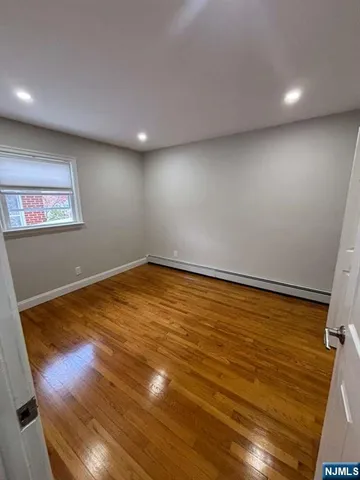 a view of room with window and wooden floor