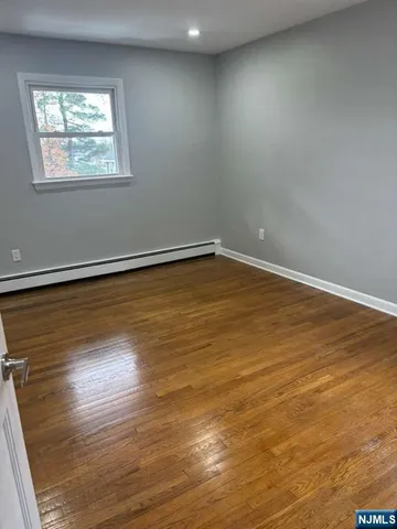 en empty room with wooden floor and windows