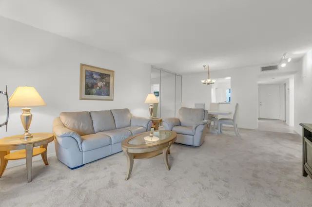 a living room with furniture a dining table and a chandelier