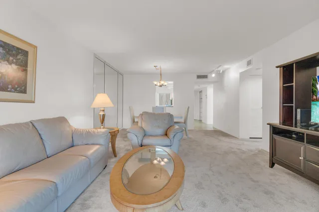 a dining room with furniture a chandelier and window