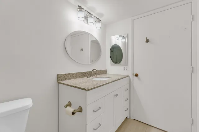 a bathroom with a sink toilet vanity and shower