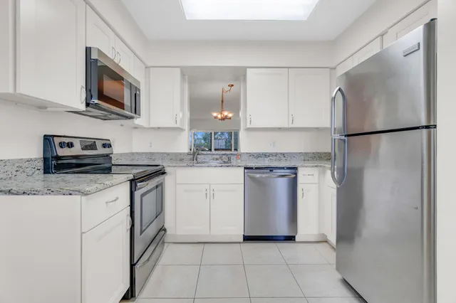 a kitchen with granite countertop a stove and a microwave