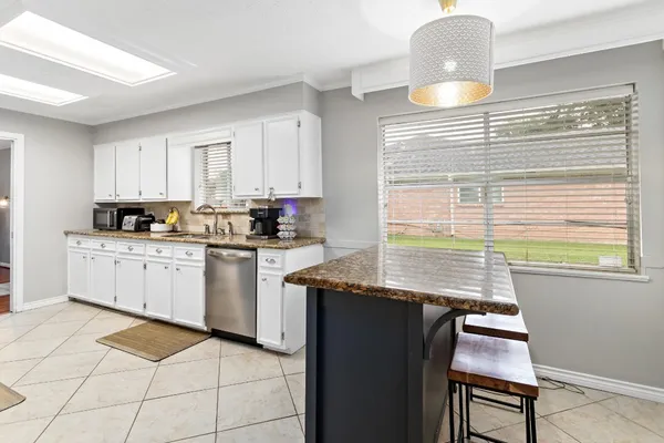 a kitchen with stainless steel appliances granite countertop a stove a sink and a microwave