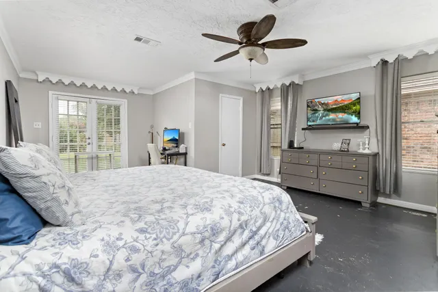 a bedroom with a bed a dresser and a flat screen tv