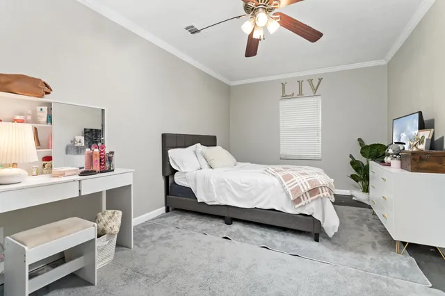 a bedroom with a bed chandelier and a window