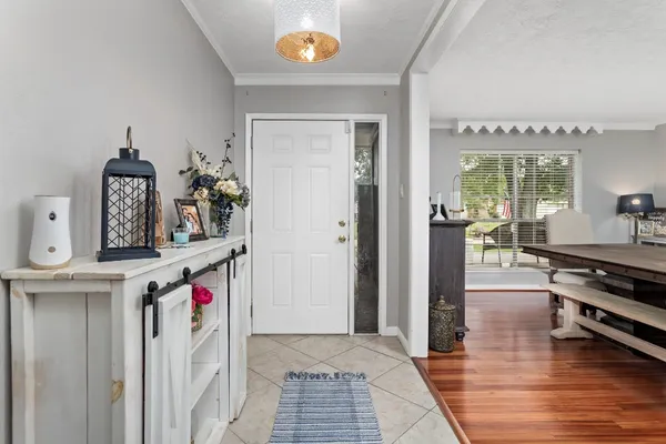 a view of a hallway with entryway and dining table