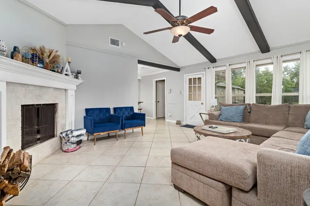 a living room with furniture a ceiling fan and a fireplace