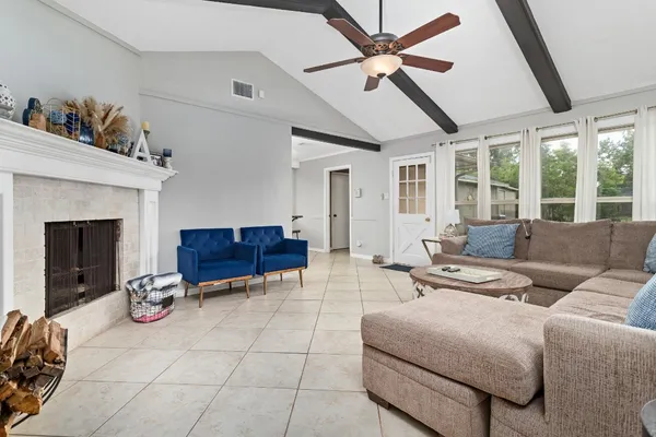 a living room with furniture a ceiling fan and a fireplace