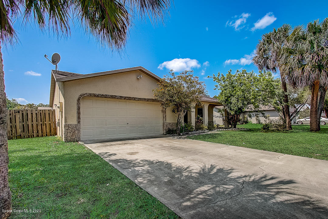 192 Cinnamon Bay Lane Melbourne, FL 32901 - Photo 2 of 34 a front view of a house with a yard and garage