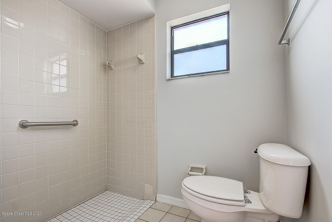 192 Cinnamon Bay Lane Melbourne, FL 32901 - Photo 20 of 34 a white toilet sitting next to a bathroom sink and vanity