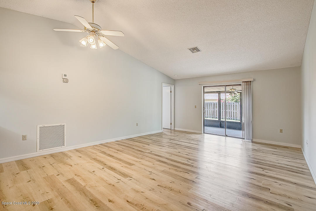192 Cinnamon Bay Lane Melbourne, FL 32901 - Photo 7 of 34 a view of an empty room with wooden floor and a window