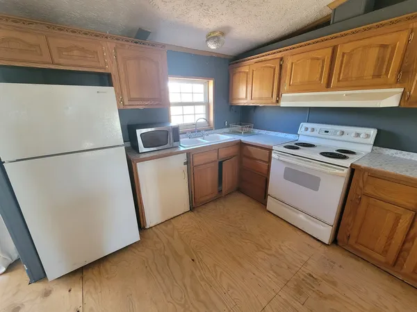 a kitchen with a sink a stove a refrigerator and cabinets