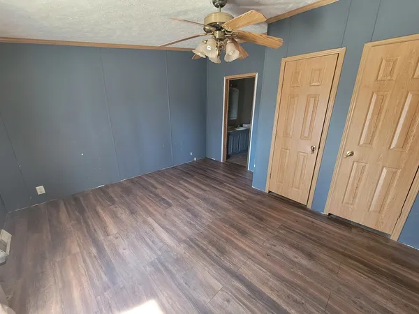a view of a room with wooden floor and ceiling fan