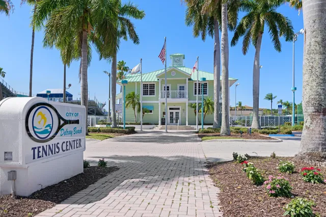 a front view of a house with garden and trees