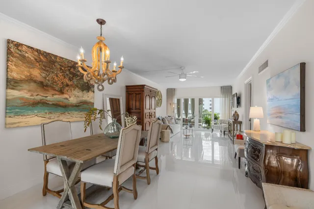 a view of a dining room with furniture a chandelier and large window