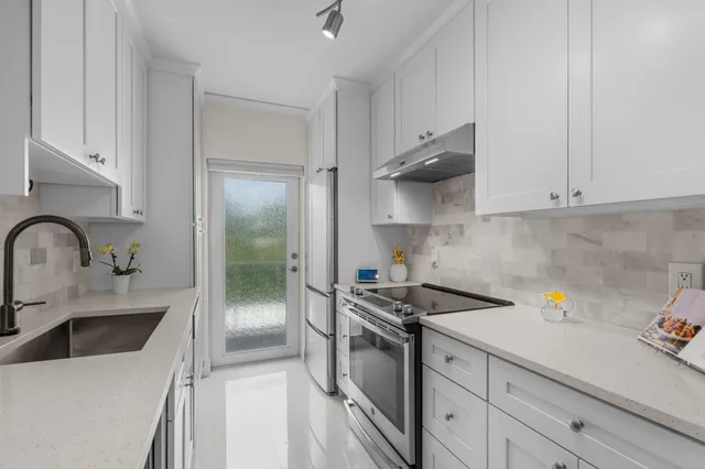 a kitchen with stainless steel appliances a sink stove and refrigerator